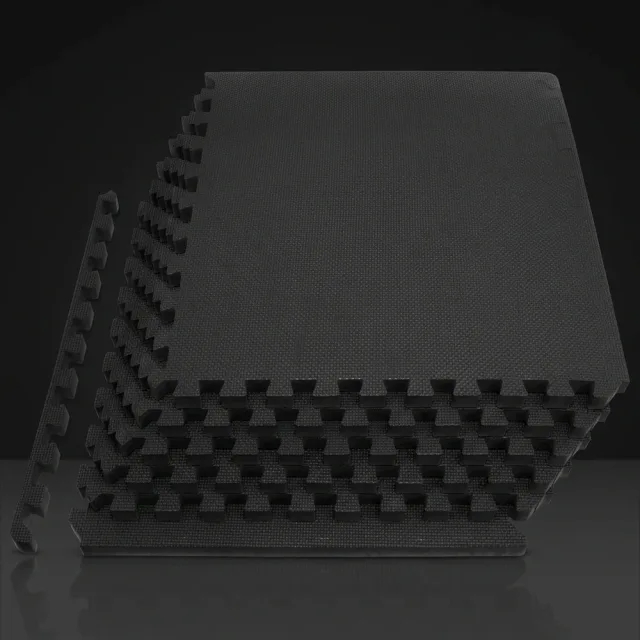 Stack of black ProsourceFit EVA foam puzzle tiles with interlocking edges against a dark studio backdrop